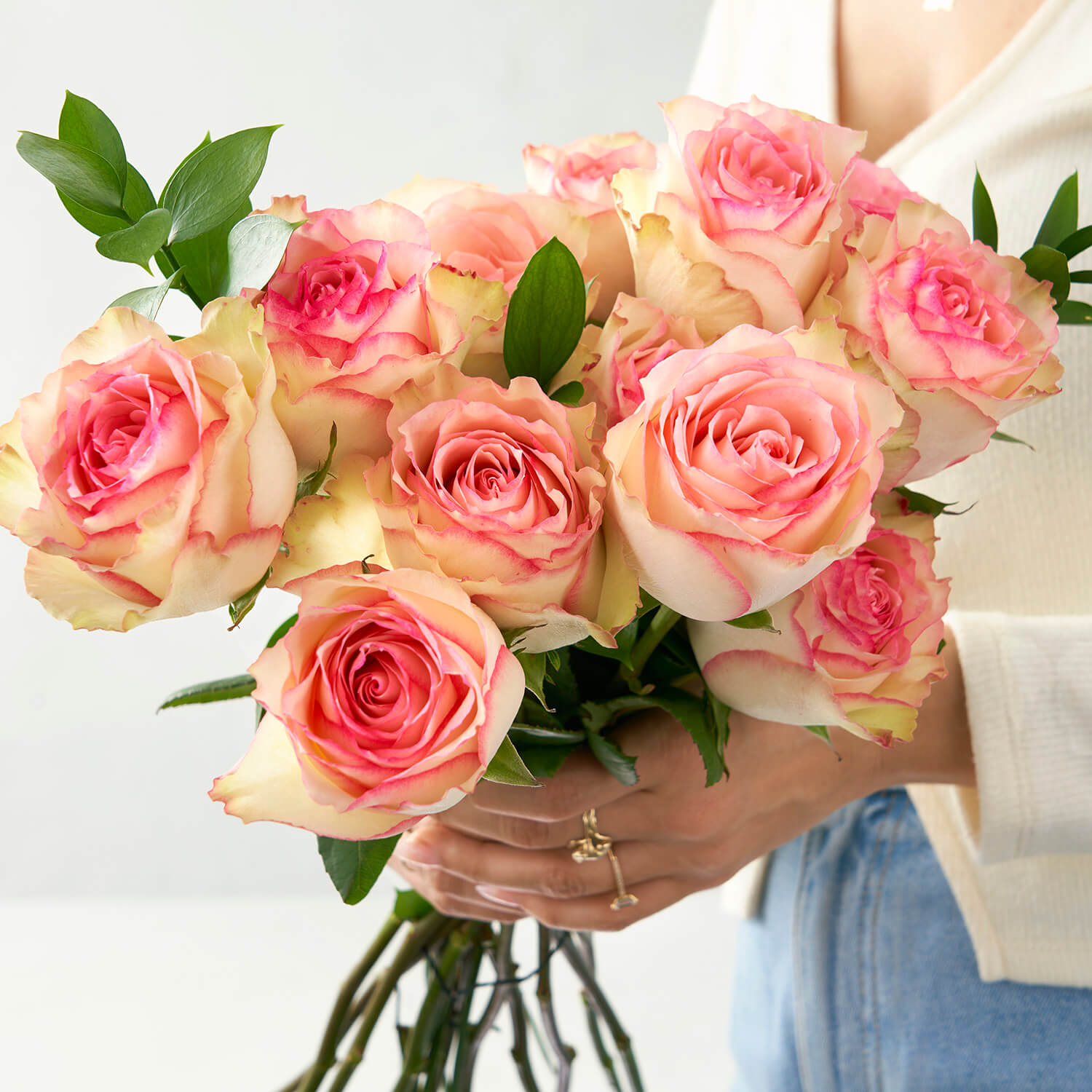 woman wearing jeans holding 12 esperance roses
