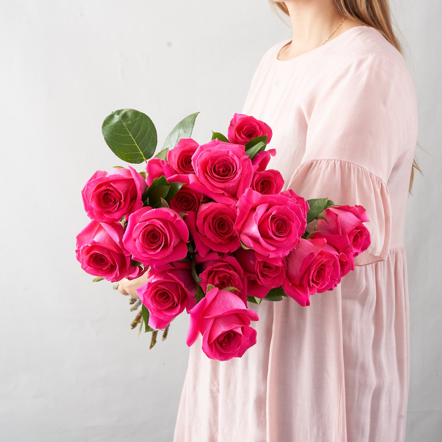 Hot pink gotcha roses in woman's arms.