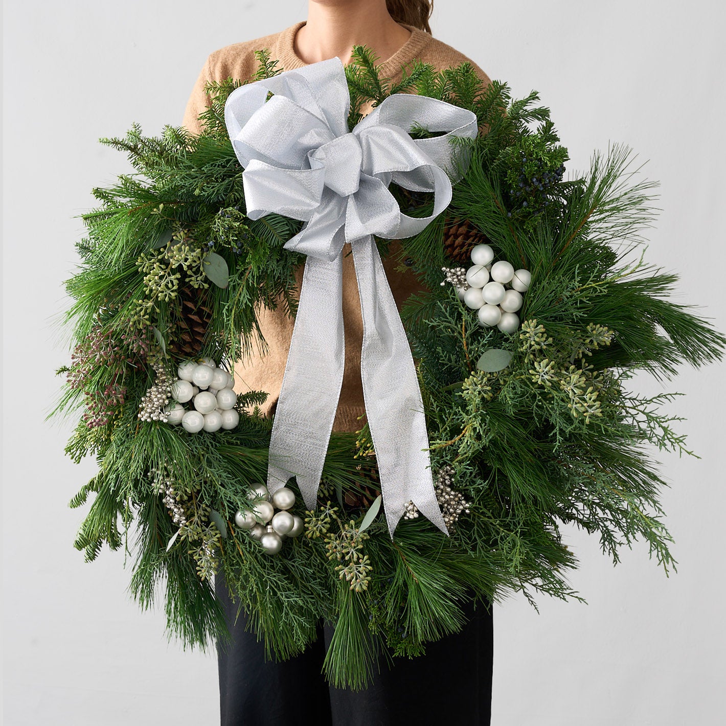 Large fresh winter green wreath with silver and white berries, pinecones, eucalyptus seed and silver bow