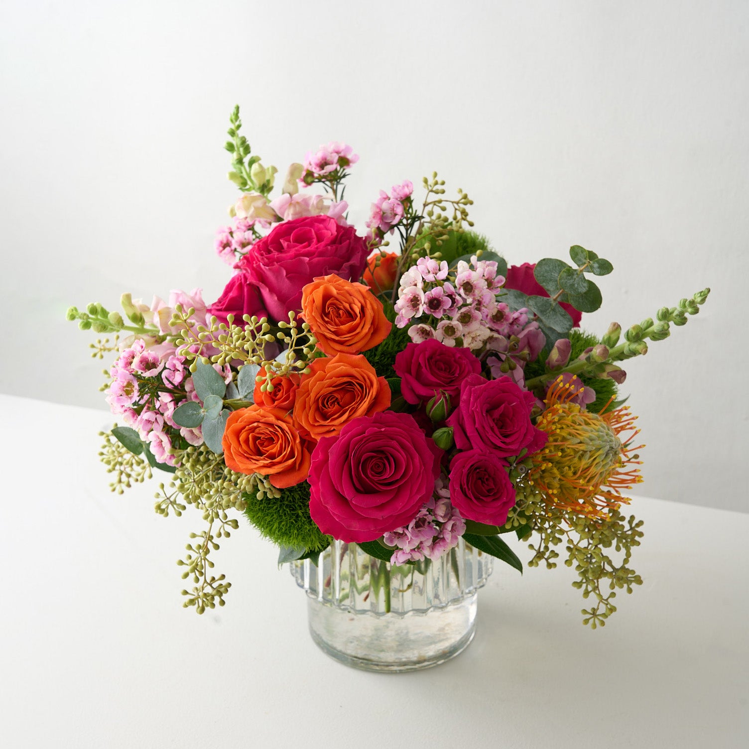 creative photo of Easter flower arrangement with colorful flowers in a ribbed vase.