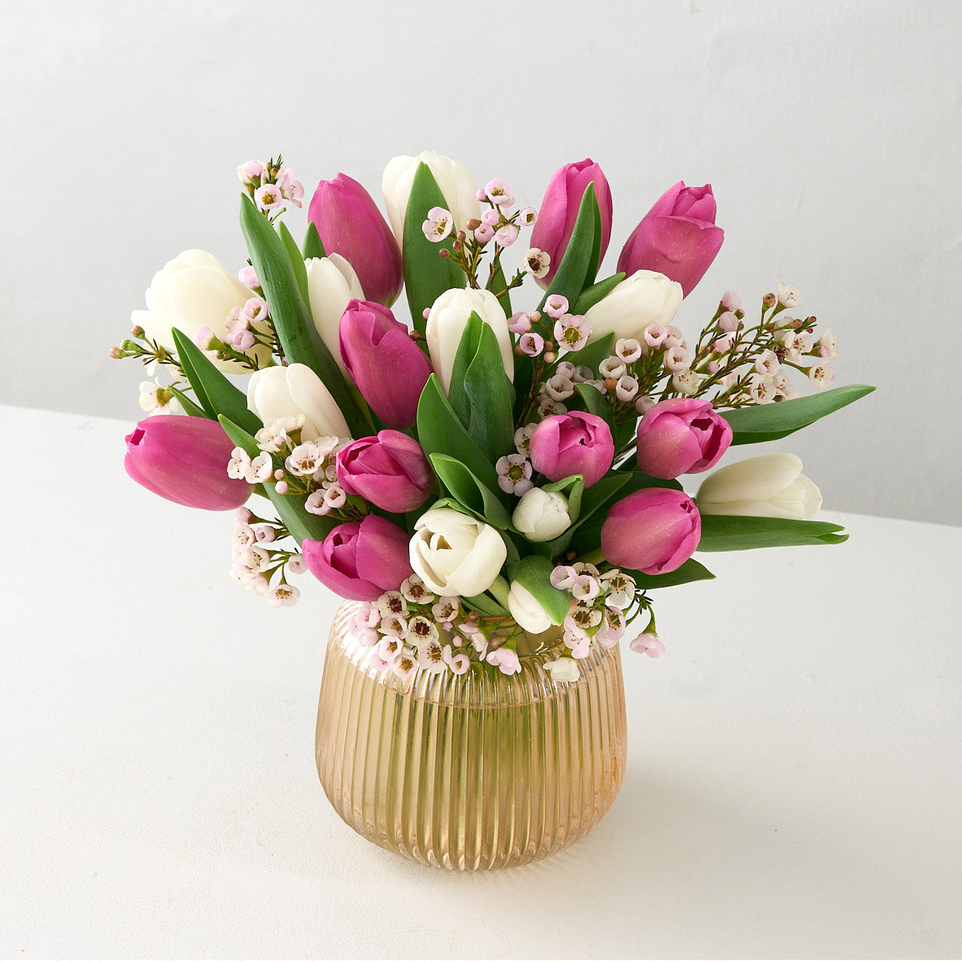 pink golden ribbed vase with pink and white tulips