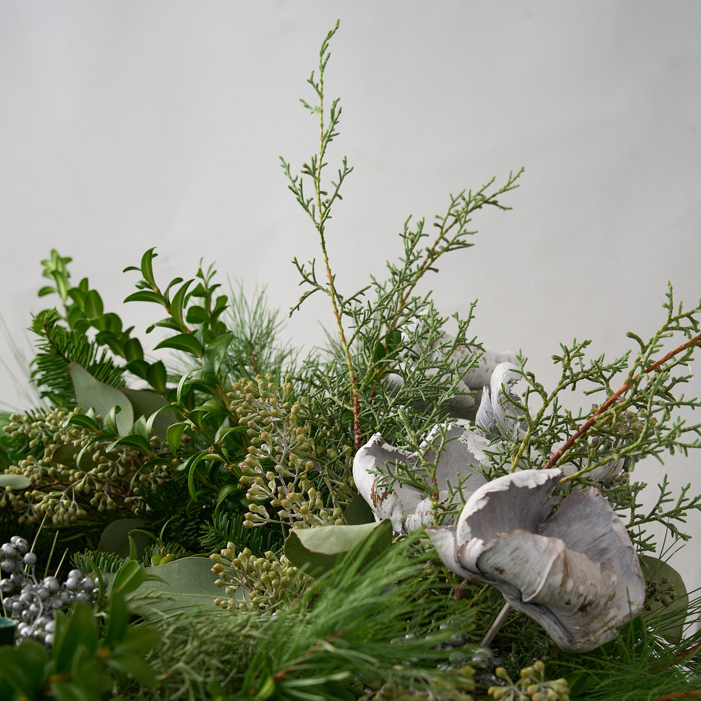 up close picture of winter greens, cedar , seeded eucalyptus, boxwood