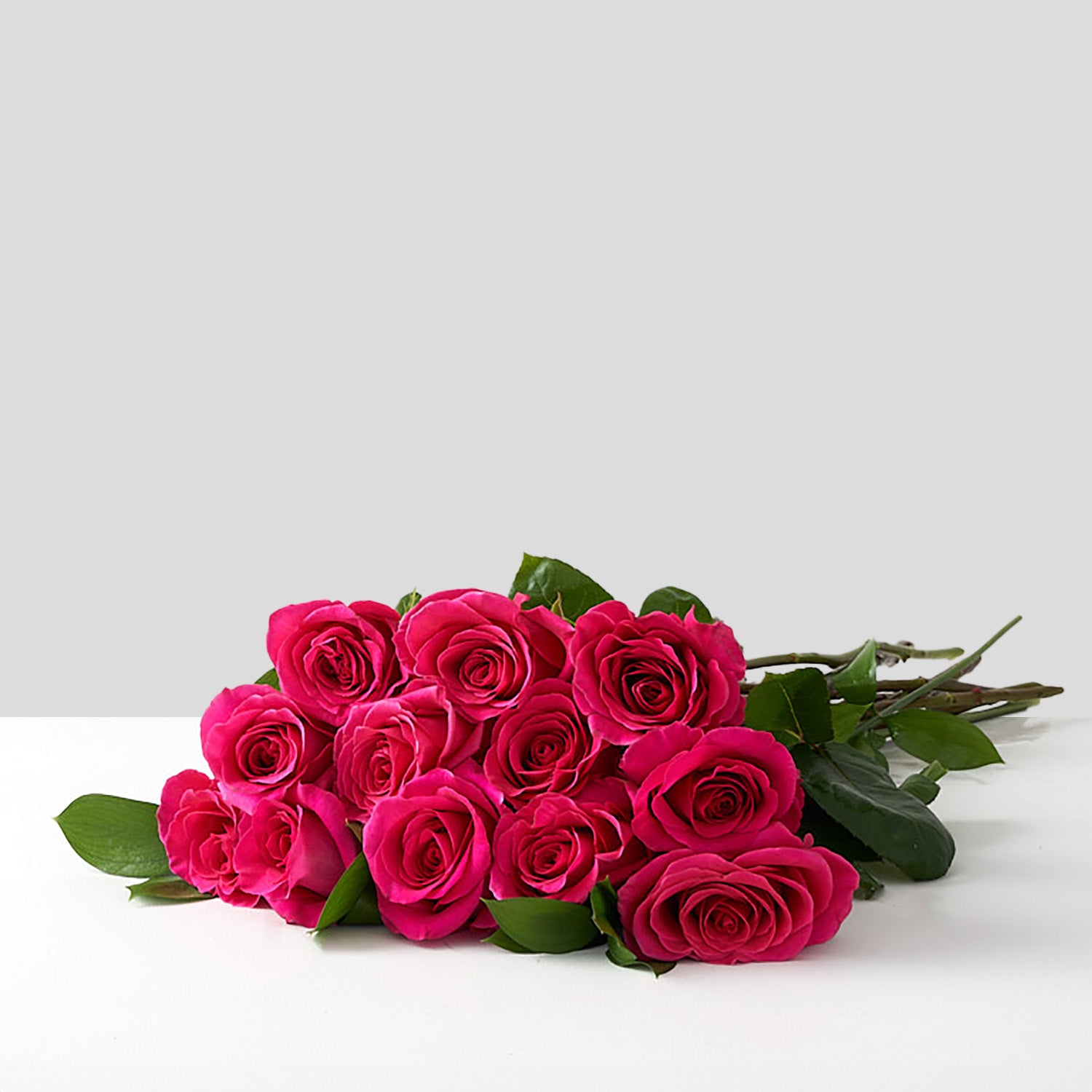 Hot pink stiletto roses on a white table