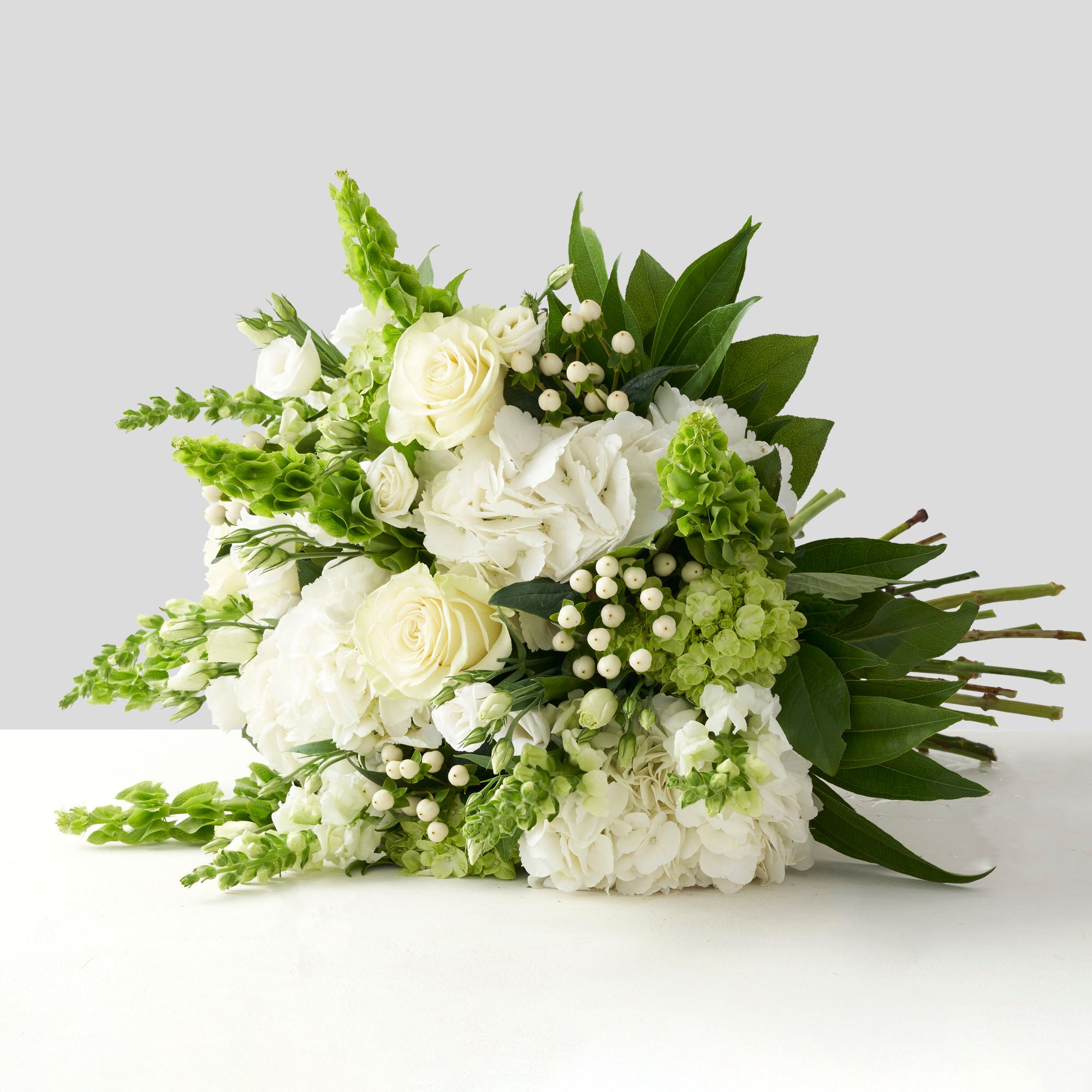 All white and green handtied bouquet on white background.