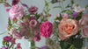 A panoramic of peach and pink flowers including ranunculus and roses.