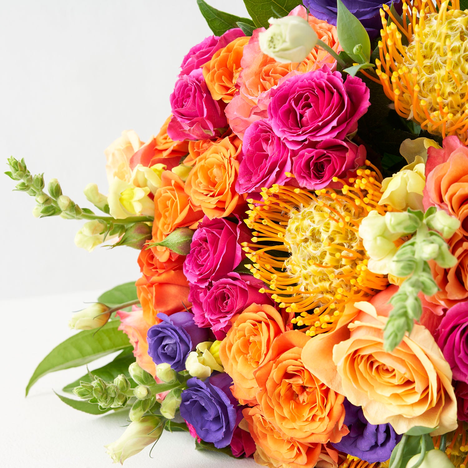 Close up of brightlly coloured flowers in shades of orange, dark purple, and hot pink.