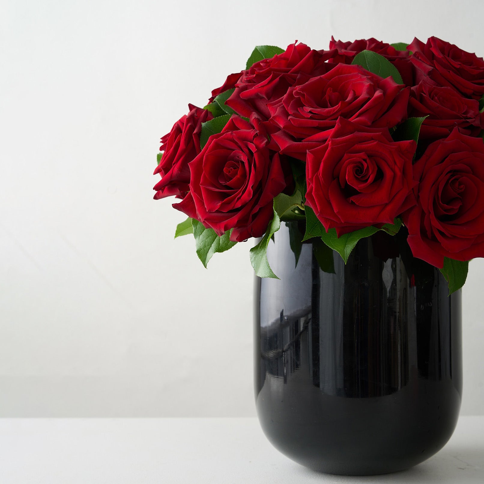 18 roses rouges dans un vase en verre noir premium