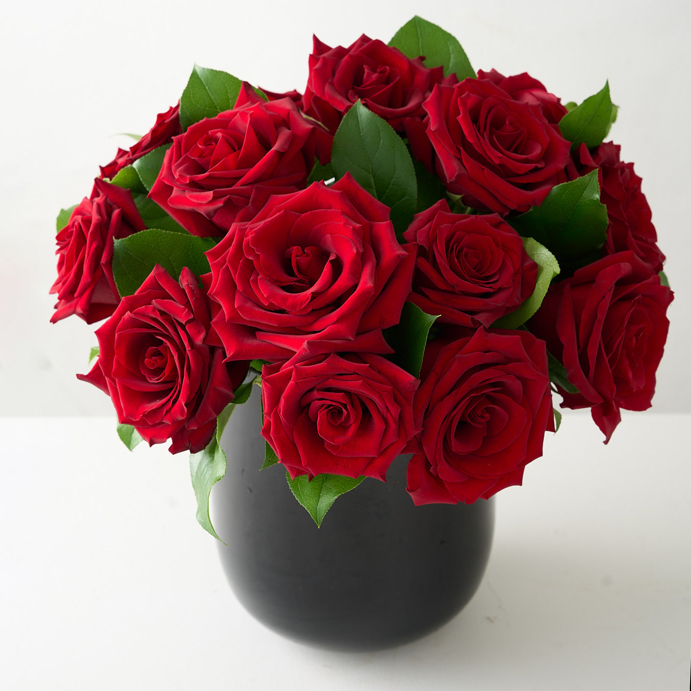 18 roses rouges dans un vase en verre noir premium