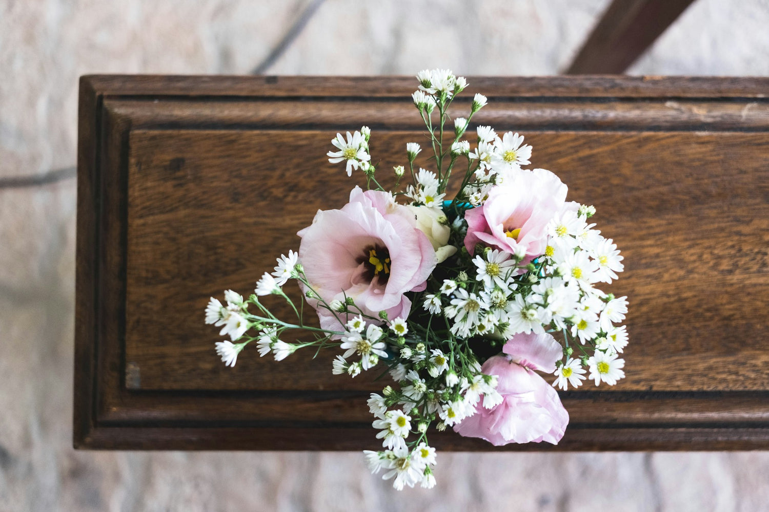 Brown coffin with pink and white flowers on top