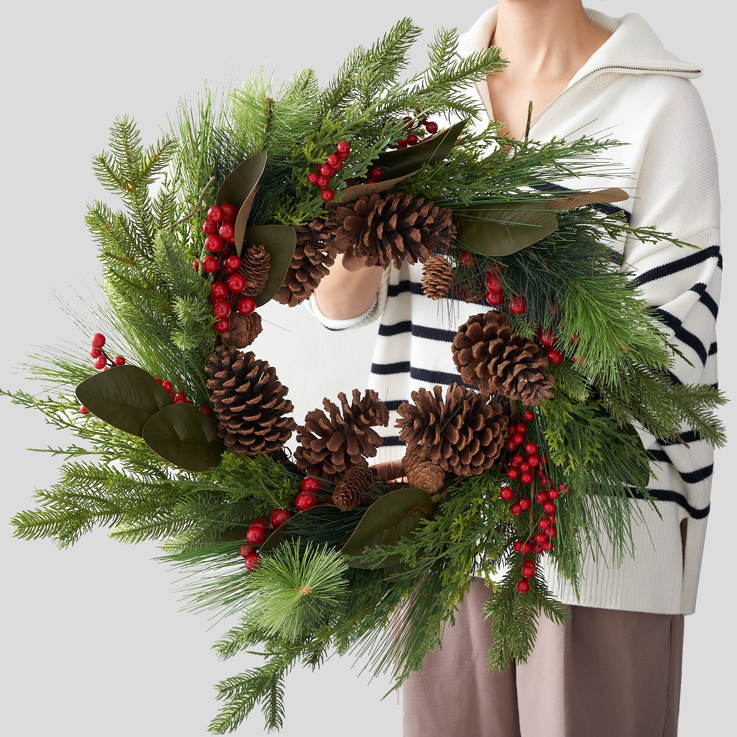 false pine, balsam and cedar wreath with red berries, pine condes and magnolia leaves