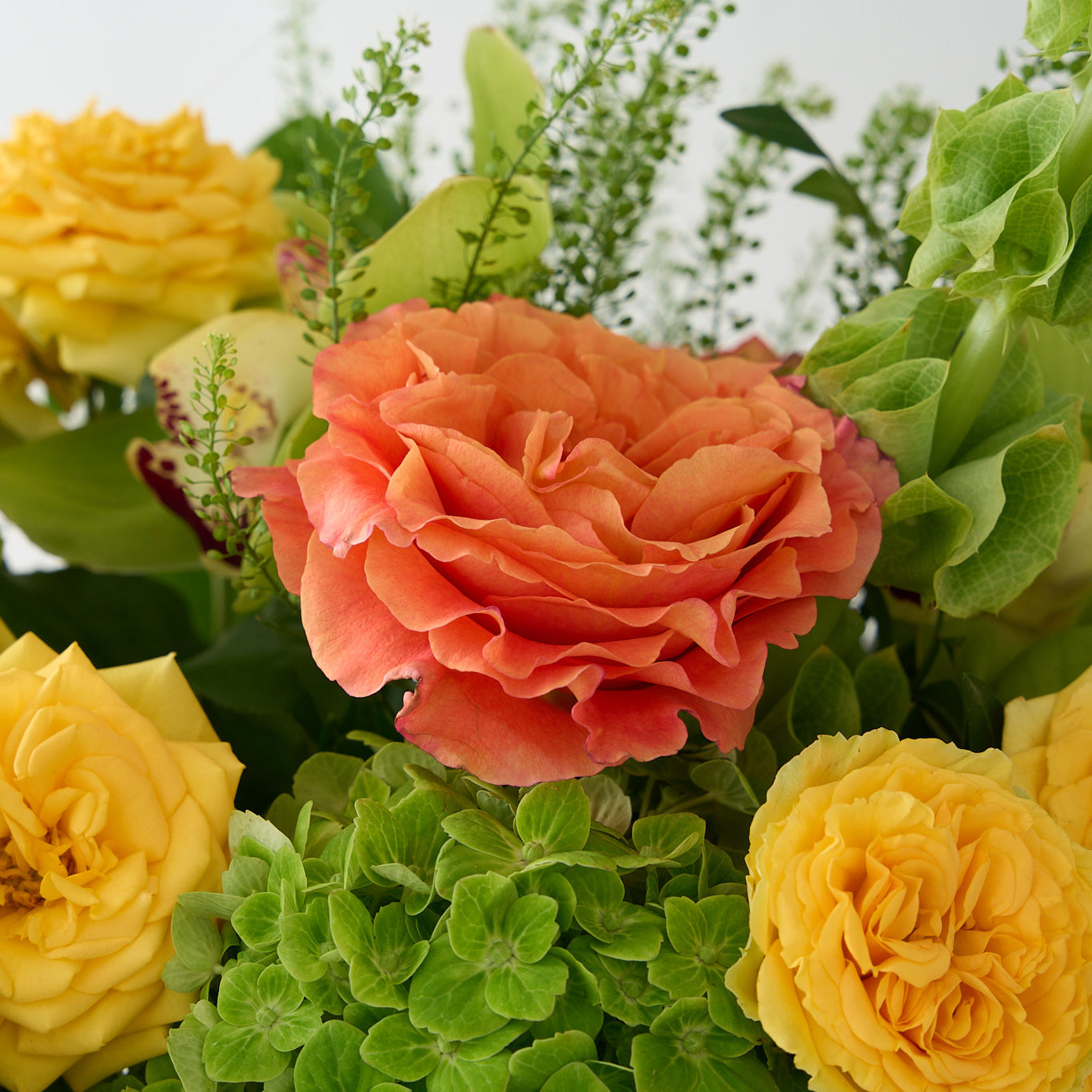 Up close photo of yellow, orange and green flowers.