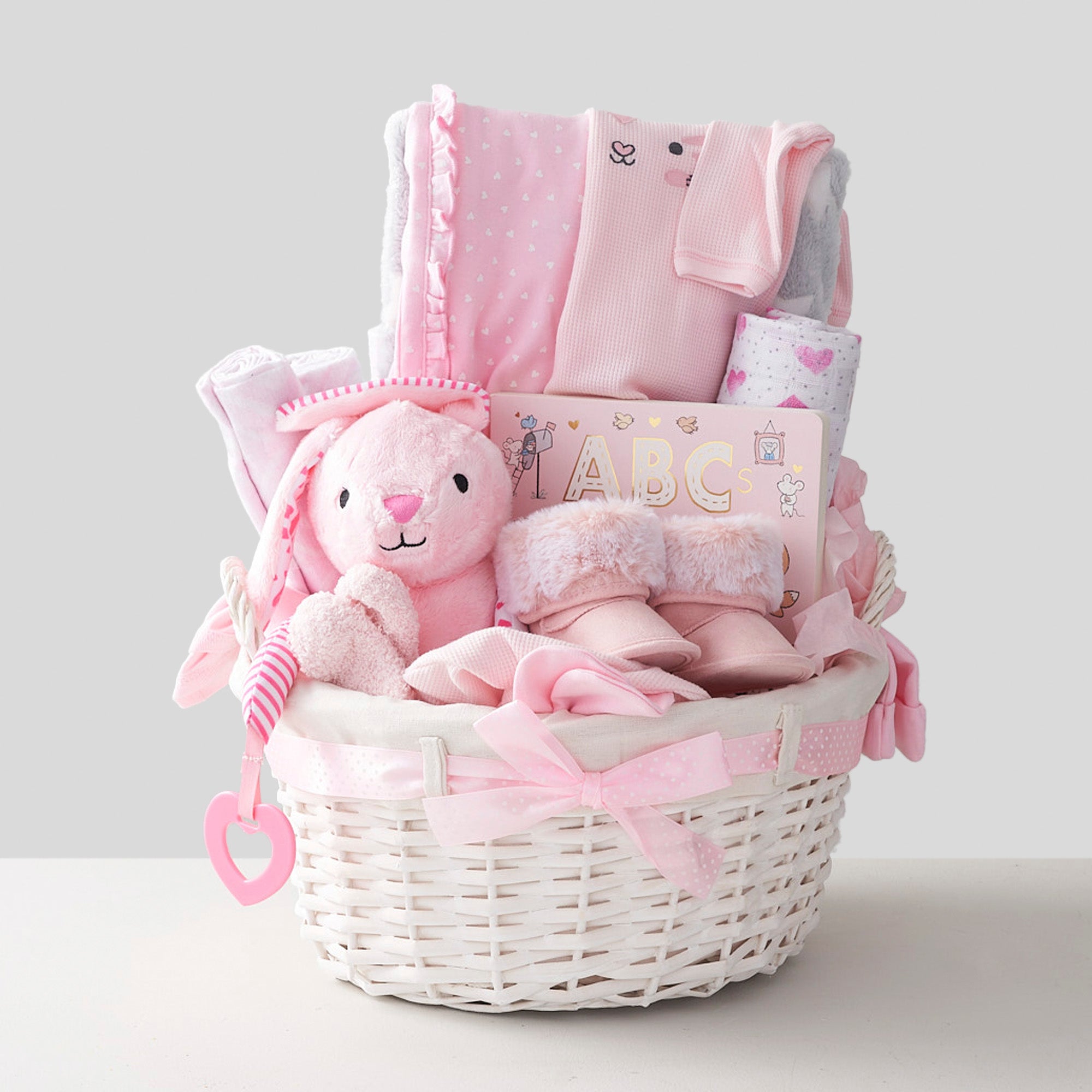 Pink baby basket for newborn with teddy bear, book, clothes, pajamas, toys and shoes