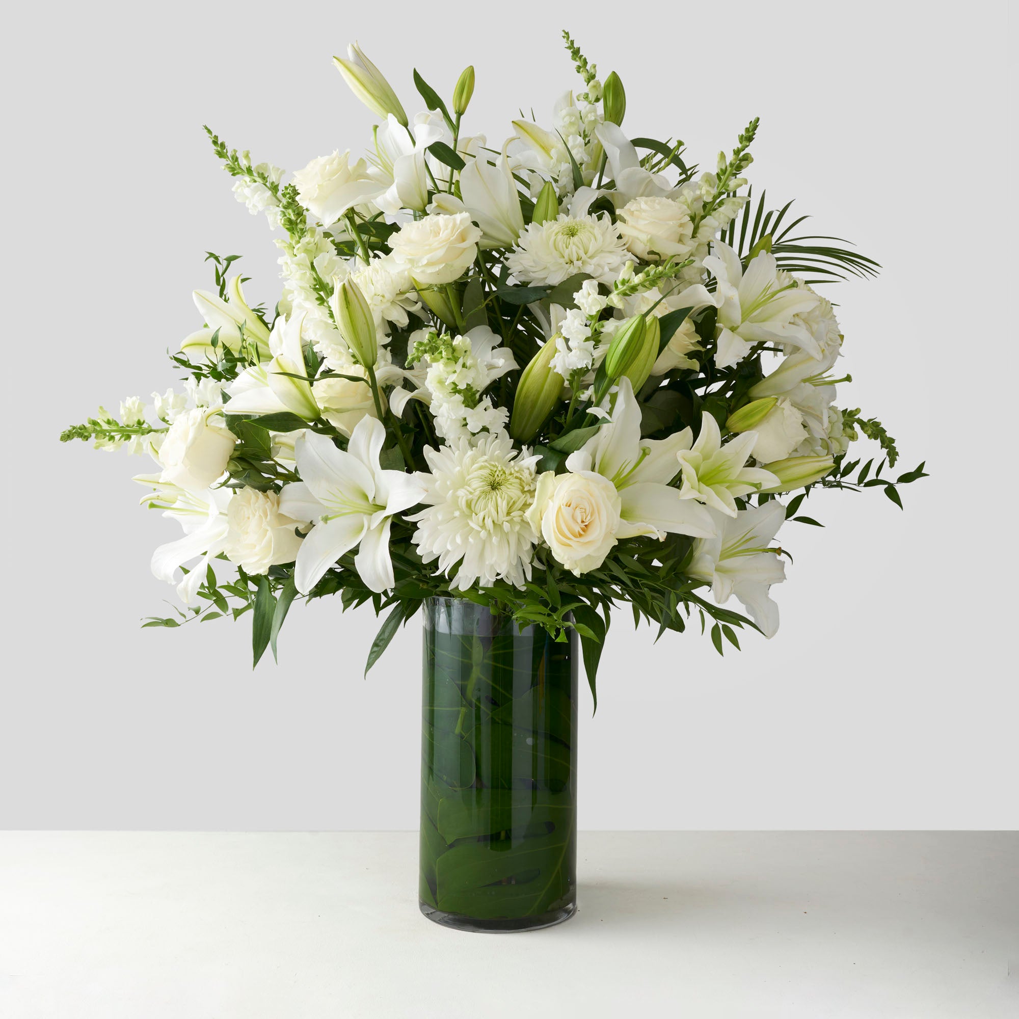 Large glass vase filled with white flowers.