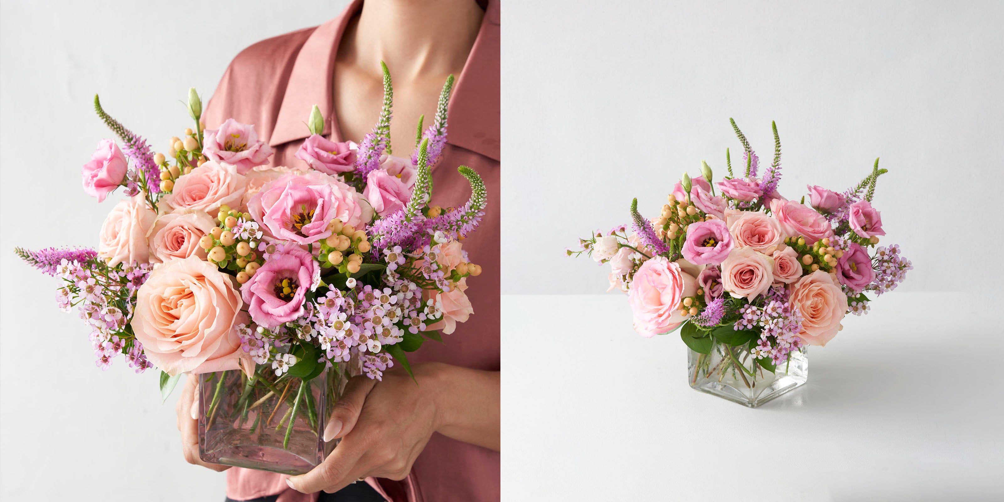 Woman in pink shirt holding glass vase full of peach and pink flowers and same vase of flowers on white background.