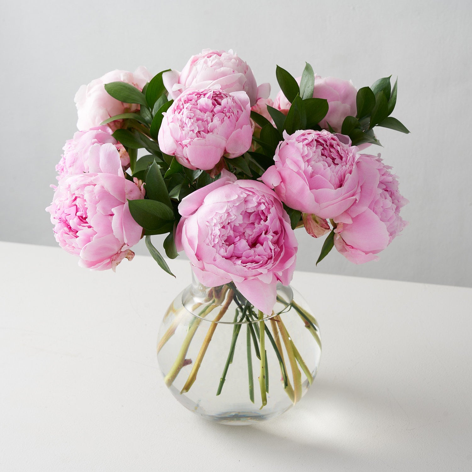 Pink peonies in clear glass vase